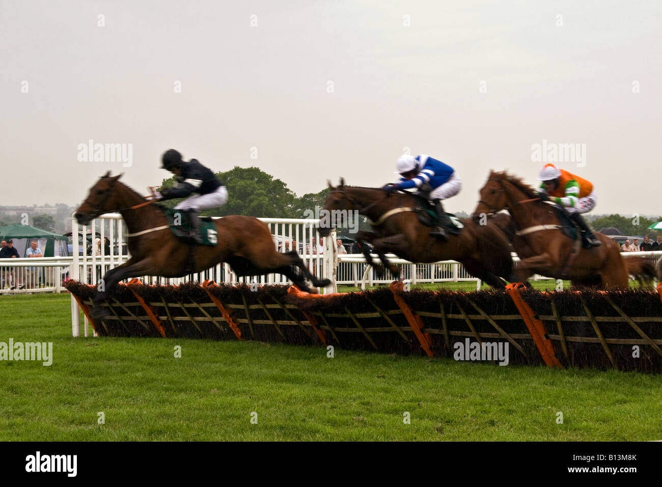 Horses and Jockey`s jumping over the hurdles during The Gold Cup
